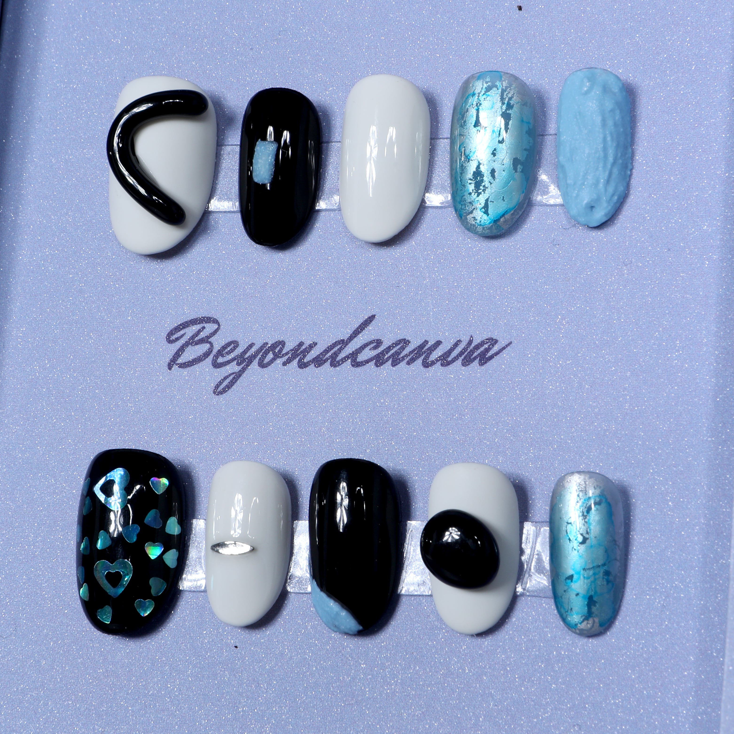 This beyondcanva press-on nail set features striking black, white, and blue tones with unique textures and holographic accents. Perfect for a bold, modern look.