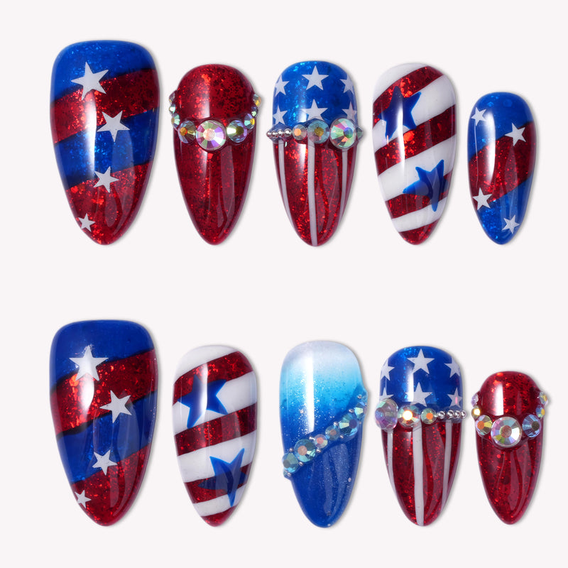 A set of 10 almond-shaped press-on nails with patriotic American flag theme in shimmering red, white, and blue with hand-painted stars and stripes, rhinestone rows, and glitter finishes, displayed in two rows on a plain white background