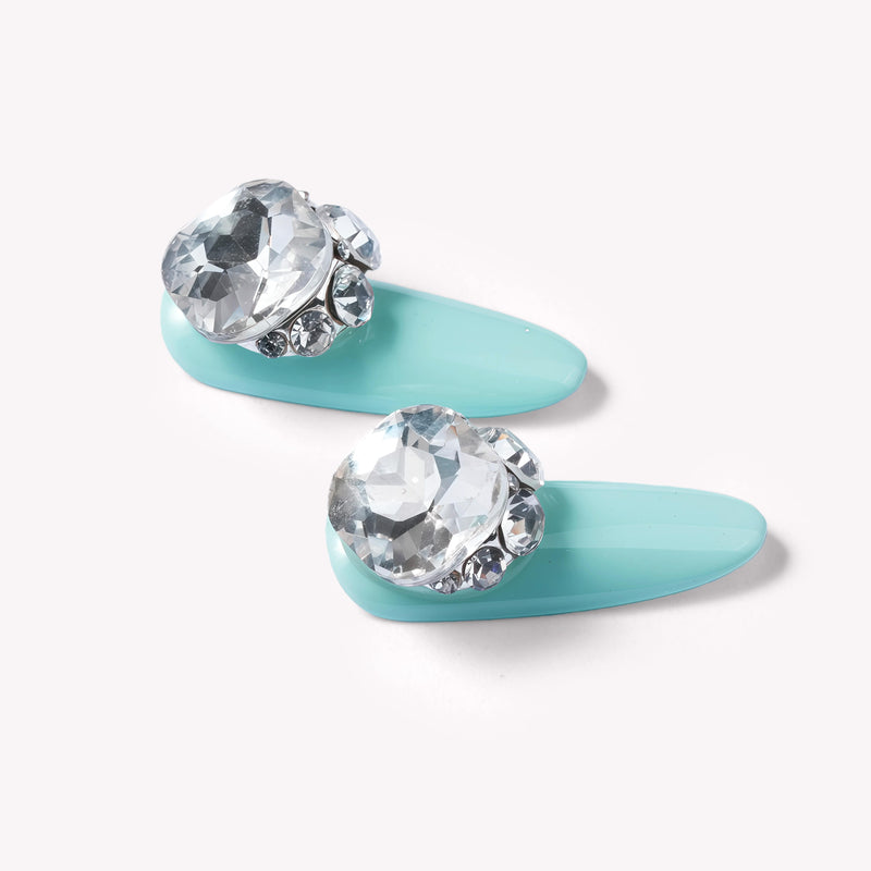Closeup of Aqua Bijou press-on nails with mint blue base and oversized crystal embellishments