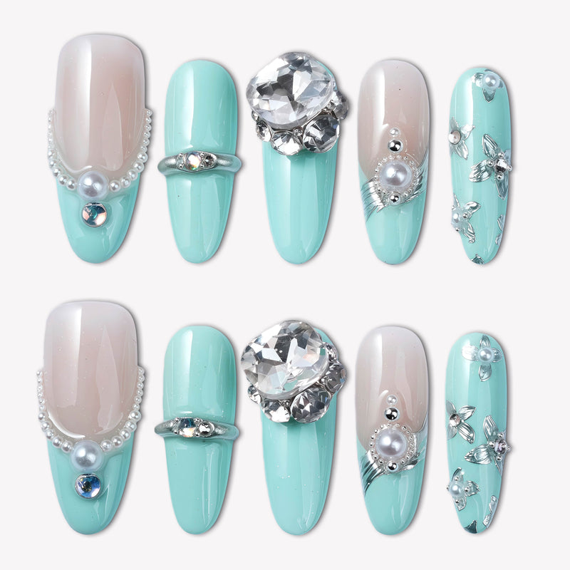 Flat lay of Aqua Bijou press-on nails with mint blue and ivory tones, pearl accents, and large crystal embellishments