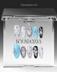 Artisian Orbit press-on nails displayed in a clear BeyondCanva case with white, black, and blue accents, pearl details, and gem embellishments