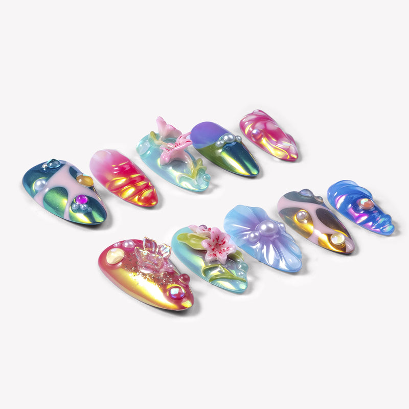 Angled flat lay of Aurora Petals iridescent multicolor press-on nails with sculpted flowers, pearls, gems and chrome swirls