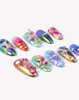 Angled flat lay of Aurora Petals iridescent multicolor press-on nails with sculpted flowers, pearls, gems and chrome swirls