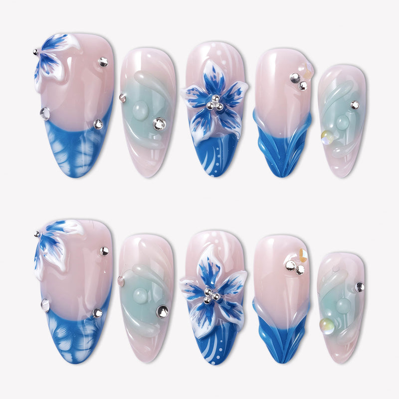 Azure Bloom press-on nails with pink bases, blue floral art, sculpted petals, pale aqua swirls, and silver rhinestones