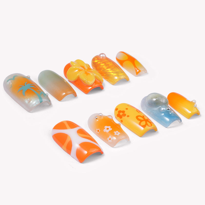 Individual press-on nail tips arranged on a white background with palm tree, flower, glitter, and abstract orange, yellow, and blue designs.