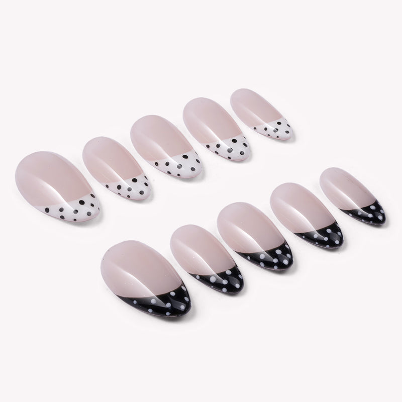 Bare Polka press-on nail set in nude pink with black and white polka dot tips arranged on a white background