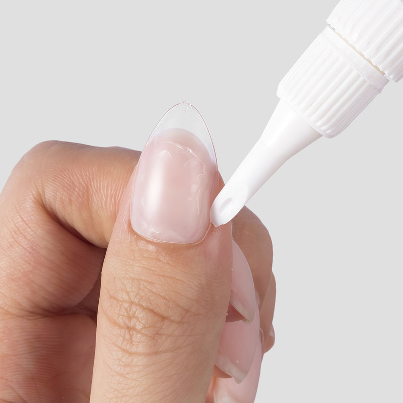 Close-up of Beyondcanva glue remover pen applying remover along the edge of a clear press-on nail