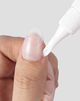 Close-up of Beyondcanva glue remover pen applying remover along the edge of a clear press-on nail