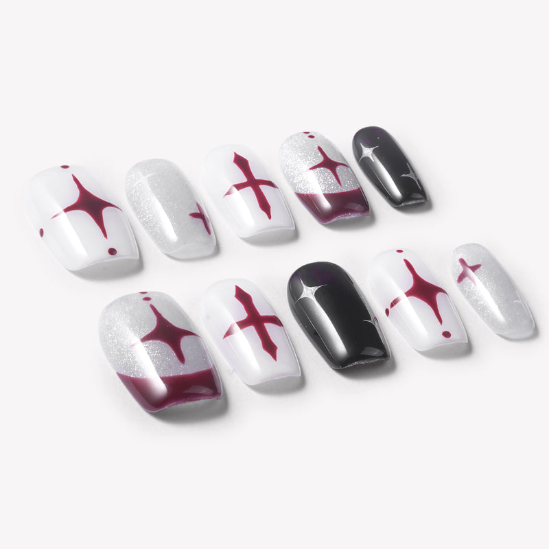 Flat lay of Blood Moon Cross press-on nails with black, white, silver glitter, and burgundy designs, cross starburst accents, curved moon tips, and glossy square shapes