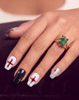 Hand model wearing Blood Moon Cross press-on nails with white, black, silver glitter, and burgundy designs, cross starburst accents, and glossy square shapes