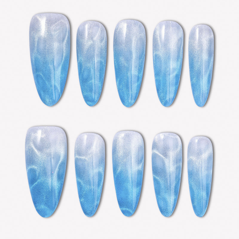 Blue Mirage press-on nails with a sky blue to white gradient, glossy cat-eye shimmer, and soft water-ripple effect