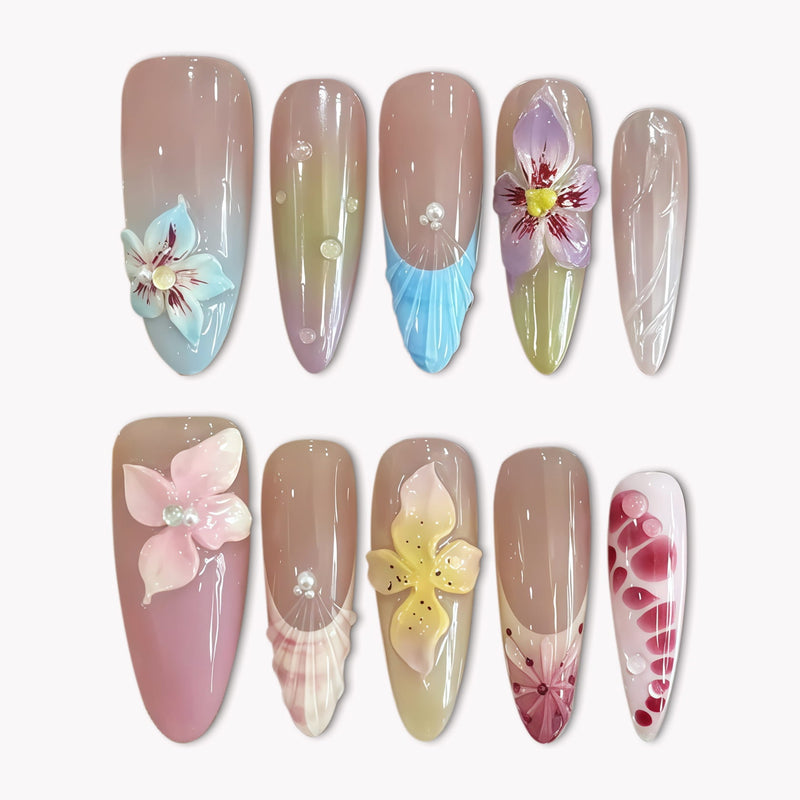 Flat lay of multicolor floral press-on nails with pastel blue, pink, yellow, and burgundy flower details on a white background.