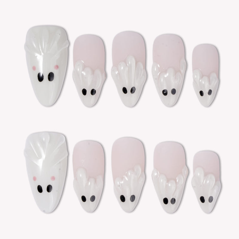 Boo Cuties press-on nails with soft white and pale pink bases, raised ghost shapes, black eyes, and tiny pink cheeks