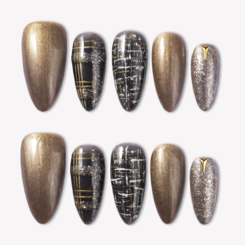 Flat lay of bronzed press-on nails with black plaid, gold stripe, and glitter accents