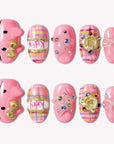 Bubblegum Pop Arcade handmade press-on nails in pink with plaid, gold accents, gems, and a bow on a white background.