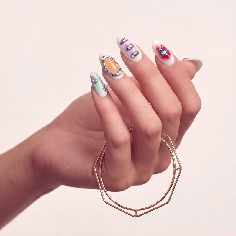 Hand model wearing Candy Chrome press-on nails with silver chrome outlines, pastel candy colors, star charm, glossy accents, and rhinestone details