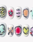 Candy Chrome press-on nails with silver chrome outlines, pastel candy colors, heart star and bow designs, glossy accents, and rhinestone details
