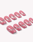 Candy Spark pink press-on nails arranged in a flat lay with silver glitter accents on a white background