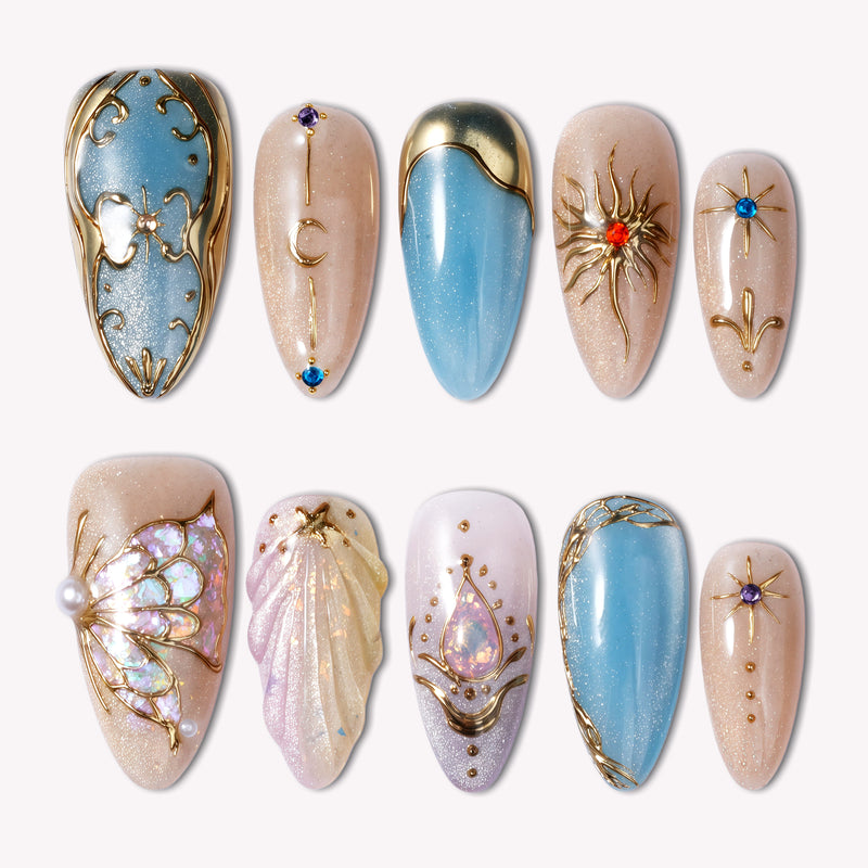 Celestial Gilded Fantasy handmade press-on nails with blue and nude bases, gold celestial accents, stars, and moons