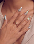 Hand model wearing Celestial Tide press-on nails with silver glitter, gold accents, pale blue stones, and pearl details