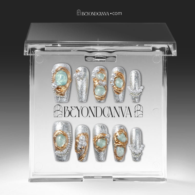 Celestial Tide press-on nails displayed in a clear Beyondcanva packaging case with silver glitter, gold swirls, and pearl accents inside