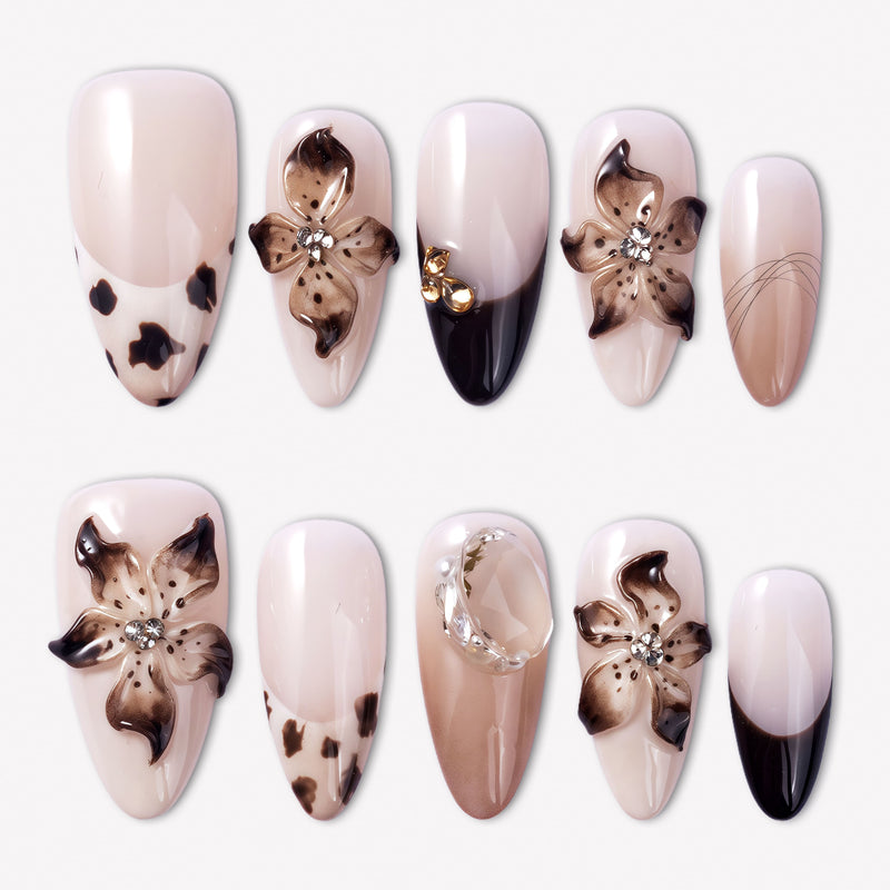 Chestnut Bloom press-on nails with nude pink bases, brown floral petals, black French accents, rhinestones, and glossy finish