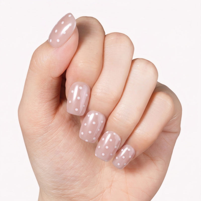 Classic Daily Set press-on nails worn on a hand with glossy pink nails and white polka dots