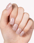 Classic Daily Set press-on nails worn on a hand with glossy pink nails and white polka dots