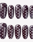 Cocoa Dots press-on nails with glossy dark brown bases and raised white polka dot designs arranged in a flat lay
