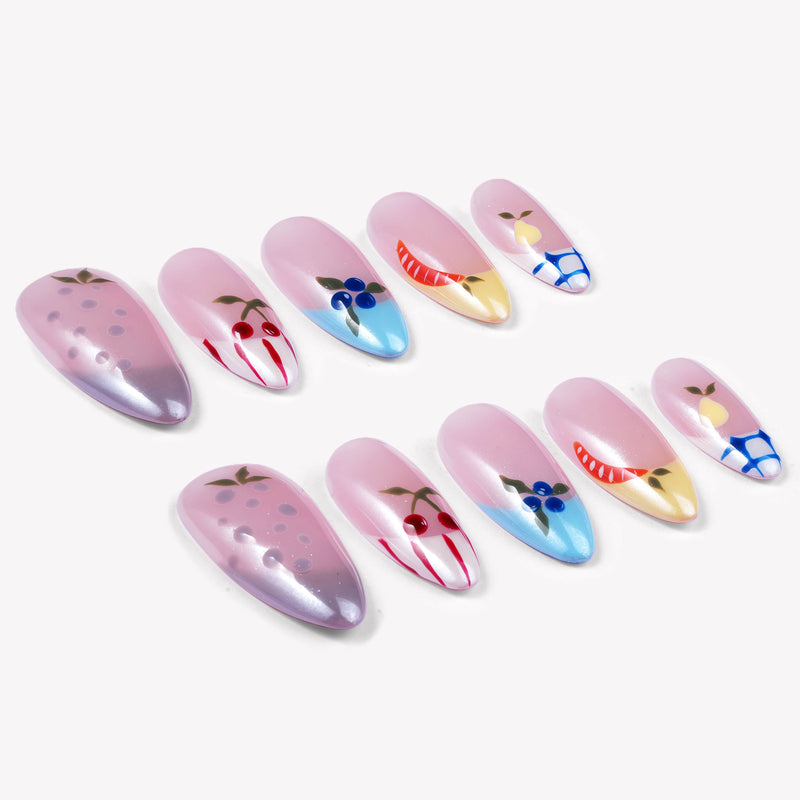 Diagonal flat lay of Colorful Harvest press-on nails with pastel pink, lavender, blue, and yellow fruit accents