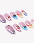 Diagonal flat lay of Colorful Harvest press-on nails with pastel pink, lavender, blue, and yellow fruit accents
