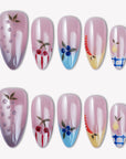 Flat lay of Colorful Harvest press-on nails with pastel pink, lavender, blue, yellow, and fruit accents arranged in two rows