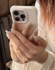 Model holding a phone while wearing Crystal Leaves silver iridescent press-on nails with mosaic leaf details