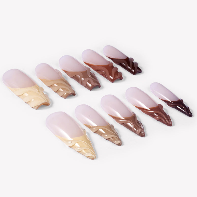 Angled flat lay of Dance of Shifting Sands press-on nails with sheer nude bases and sculpted sand to brown wave tips
