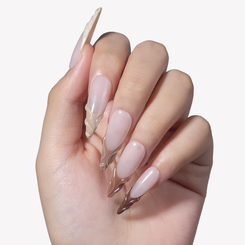 White background hand model wearing Dance of Shifting Sands press-on nails with sheer nude bases and sculpted sand brown wave tips