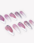 Angled flat lay of Diamond Dust pink and white stiletto press-on nails with silver glitter, rhinestones, and crystal accents