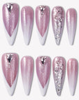 Diamond Dust pink glitter press-on nails with white V French tips, silver rhinestones, and crystal charms in a flat lay