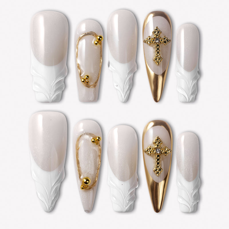 Divine Grace press-on nails with white sculpted bases, nude pearl shimmer, gold chrome accents, bead details, and rhinestone cross charms