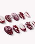 Dot Fantasy press-on nail set in red and white with polka dots and jeweled 3D accents arranged in a flat lay on a white background