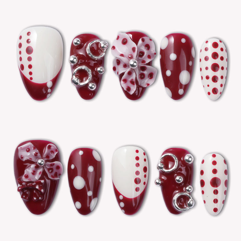 Dot Fantasy press-on nail set in red and white with polka dots and jeweled 3D accents arranged on a white background