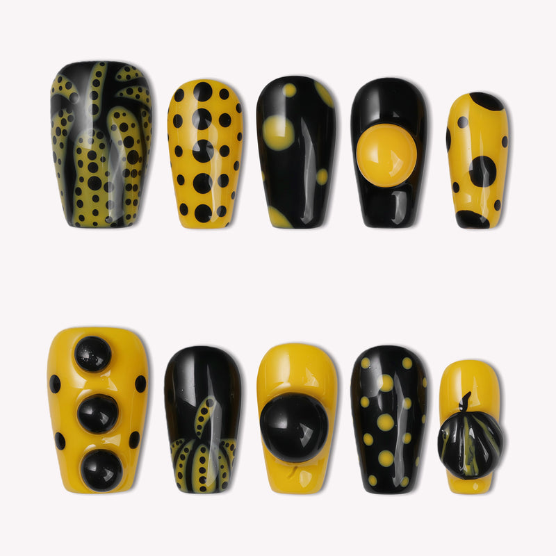 Dot Obsession press-on nails in black and yellow with bold polka dots arranged on a white background