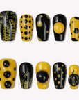 Dot Obsession press-on nails in black and yellow with bold polka dots arranged on a white background