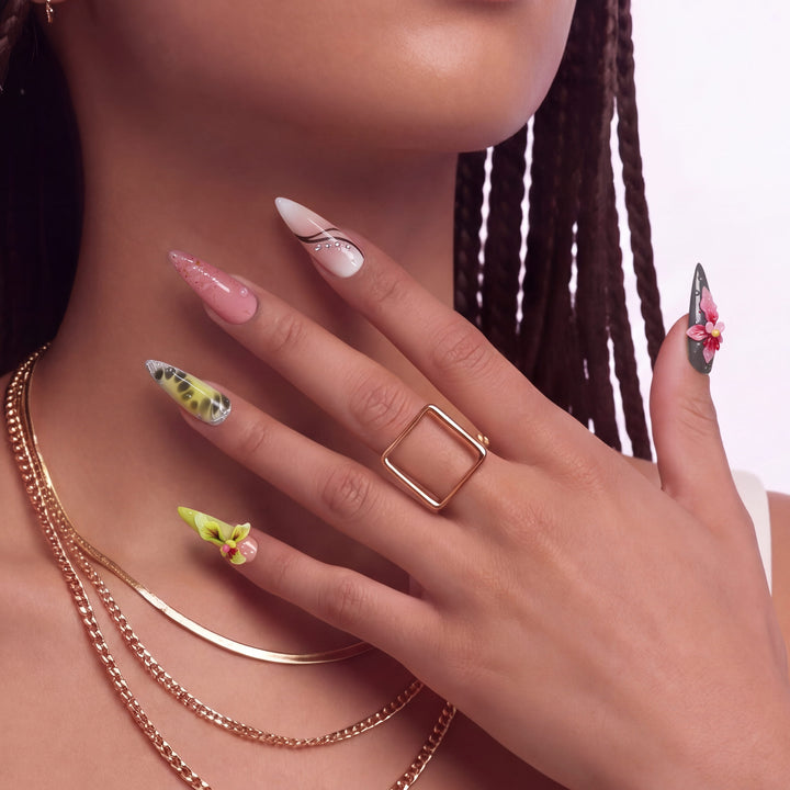 Close-up of a hand wearing multicolor floral press-on nails with pink, yellow, and green accents.