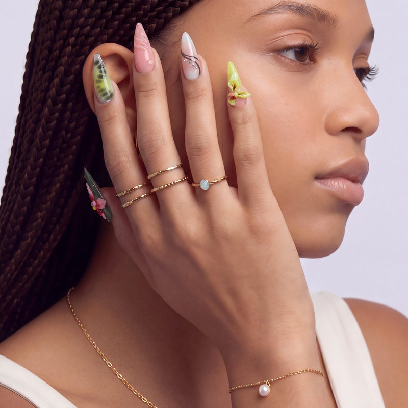 Profile of a model wearing multicolor floral press-on nails with pink, yellow, and green accents.