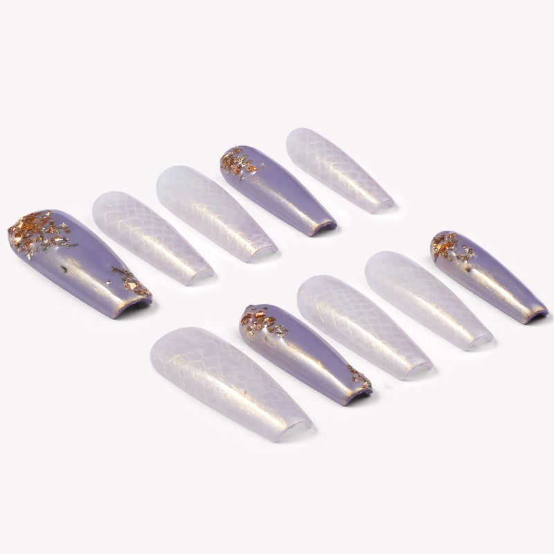 Emerald Venom press-on nails with lavender shimmer, gold foil, and snake texture arranged in a flat lay