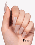 Hand model wearing Fall Essence Pearl press-on nails in a sheer nude pearl shade with glossy almond-shaped tips