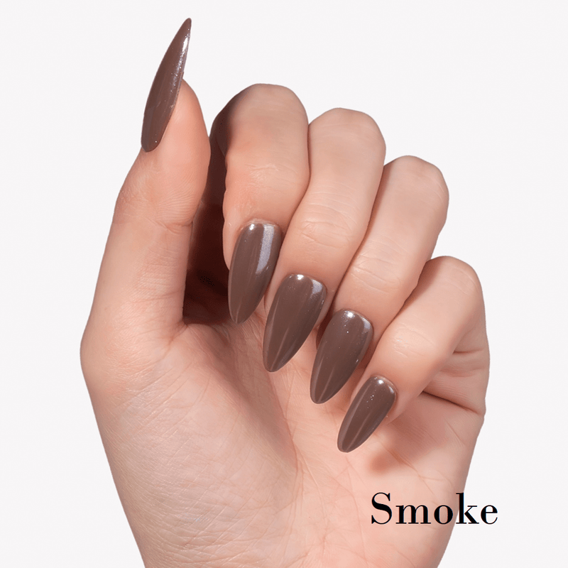 Hand model wearing Fall Essence Smoke press-on nails in a smoky gray brown shade with glossy almond-shaped tips