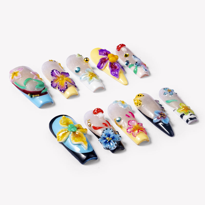 Angled flat lay of Floral Symphony press-on nails with 3D flowers, mushroom charms, rhinestones, and pastel tips