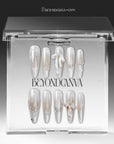 Frosted Ballet press-on nails displayed in a clear BeyondCanva case with pearl white shimmer, snowflake accents, and ribbon bows