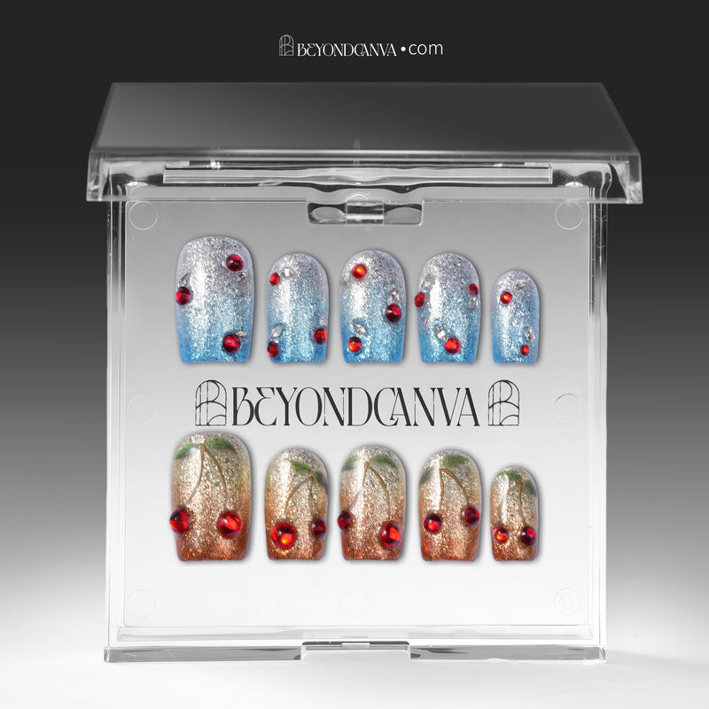 Frosted Cherry press-on nails in blue and gold glitter with red gem accents displayed in a clear packaging box